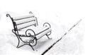 Single bench covered with snow in a winter park Royalty Free Stock Photo