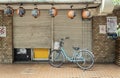 A single bicycle outside a closed shop in Tokyo, Japan. Japanese lanterns hang at the front