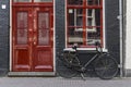 A single bicycle outside a red door in Amsterdam Royalty Free Stock Photo