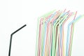 Single black drinking straw separated from a group of colorful d Royalty Free Stock Photo