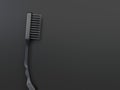 Single black one-color close-up toothbrush is isolated on a black background. Creative conceptual illustration in dark colors with