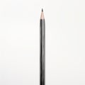 Single black pencil with sharp tip on white background. Studio photography. Royalty Free Stock Photo
