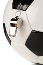 Single black and white soccer sports ball with referee whistle close up with selective focus over white