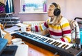 Single,blonde housewife and professiional musician working from home, using midi keyboard with recording software,England,United