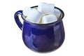 Single blue ceramic mug with handle full of many pieces of raw sweet tasty marshmallows cylindrical form isolated on white backgro