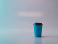 Single Blue Coffee Cup with Lid on Reflective Surface Royalty Free Stock Photo