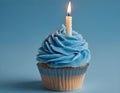 Single blue Cupcake With a Burning Candle on blue Background Royalty Free Stock Photo