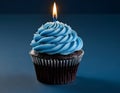 Single blue Cupcake With a Burning Candle on blue Background Royalty Free Stock Photo