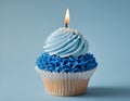 Single blue Cupcake With a Burning Candle on blue Background Royalty Free Stock Photo
