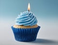 Single blue Cupcake With a Burning Candle on blue Background Royalty Free Stock Photo
