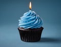 Single blue Cupcake With a Burning Candle on blue Background Royalty Free Stock Photo