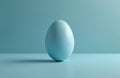 Single blue egg rests on a matching blue surface. Its smooth shell reflects soft light against a plain, monochromatic background. Royalty Free Stock Photo
