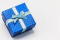 Single blue gift box with silver ribbon on white background. Royalty Free Stock Photo