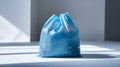 Single blue plastic bag with no contents, placed on a white surface Royalty Free Stock Photo