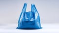 Single blue plastic bag with no contents, placed on a white surface Royalty Free Stock Photo