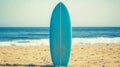 Single Blue Surfboard Stands Upright on a Sunny Sandy Beach, Ocean Waves in Background. Royalty Free Stock Photo