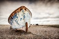 Single boat stranded on pebbled beach. Dungeness, England Royalty Free Stock Photo