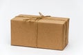 Single box wrapped with brown kraft paper and tied with twine on a white background. Delivery, moving, package concept Royalty Free Stock Photo