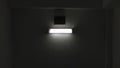 A single bright fluorescent light glowing in a dark, minimalist room. Royalty Free Stock Photo