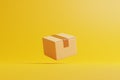 Single brown cardboard box float on a yellow background