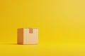 Single brown cardboard box on a yellow background