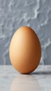 single brown egg standing upright on smooth marble surface Royalty Free Stock Photo