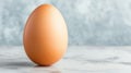 single brown egg standing upright on smooth marble surface Royalty Free Stock Photo
