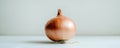 Single brown onion on light surface with white background, minimalistic food concept Royalty Free Stock Photo