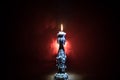 Single burning candle. Light of flame and flowing candle wax, dark background Royalty Free Stock Photo