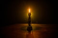 Single burning candle. Light of flame and flowing candle wax, dark background