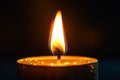 Single burning candle providing warm light in complete darkness, creating a cozy and intimate atmosphere Royalty Free Stock Photo