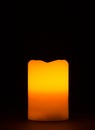 Single burning candle with warm orange red halo Royalty Free Stock Photo