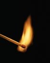 Single burning match on black background