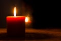 Single burning red candle and flame reflection in the dark window. Royalty Free Stock Photo