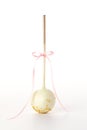 Single Cake Pop Decorated With Gold Sprinkles And A Ribbon On A White Background. Royalty Free Stock Photo