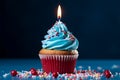 Single candle atop a blue cupcake with vibrant red sprinkles Royalty Free Stock Photo