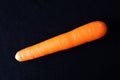 Single carrot against black background