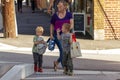 A single caucasian mother with two little boys are walking in the street