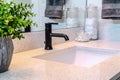 Single ceramic sink and black faucet on the vanity inside bathroom of home