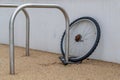 A single chained locked bicycle wheel on the street due to stealing