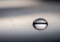 A single, clear droplet of water resting on a smooth, reflective Royalty Free Stock Photo