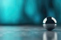 Single clear glass sphere on reflective surface with teal abstract background Royalty Free Stock Photo