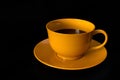 One coffee cup, yellow ceramic, on black background Royalty Free Stock Photo