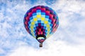 Single, colorful hot-air balloon high in the sky