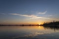 A single contrail over lake Zoetermeerse Plas is illuminated during sunset in Zoetermeer, Netherlands