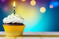 single cupcake adorned with white frosting, golden sprinkles, and lit birthday candle, soft bokeh background, banner Royalty Free Stock Photo