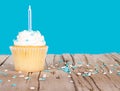 Single cupcake with blue candle and sprinkles Royalty Free Stock Photo