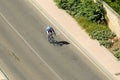 A single cyclist pedaling down a lonely road. Royalty Free Stock Photo