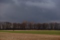 single cyclist on a street with fields and dark rain clouds Royalty Free Stock Photo