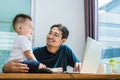 Single dad and son using laptop together happily. Technology and Royalty Free Stock Photo